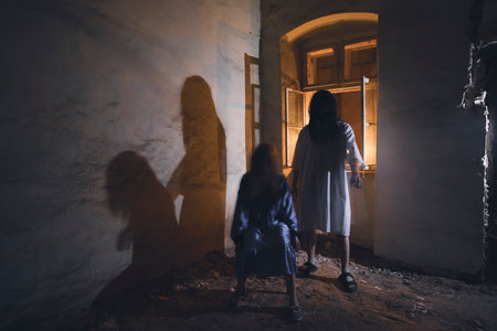 Ghosts in abandoned, haunted house. Horror scene of scary spirit of a couple, halloween concept.の写真素材