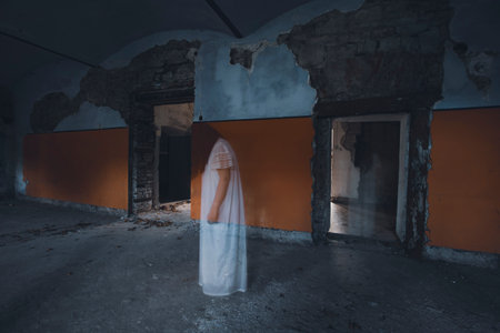Ghost in abandoned, haunted house. Horror scene of scary spirit of a woman, halloween concept.の写真素材