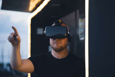 Young man wearing virtual reality goggles. Metaverse, technology, video game, futuristic conceptの写真素材