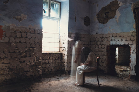Ghost in abandoned, haunted house. Horror scene of scary spirit of a woman, halloween concept.