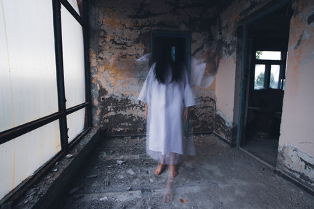 Ghost in abandoned, haunted house. Horror scene of scary spirit of a woman, halloween concept.の写真素材