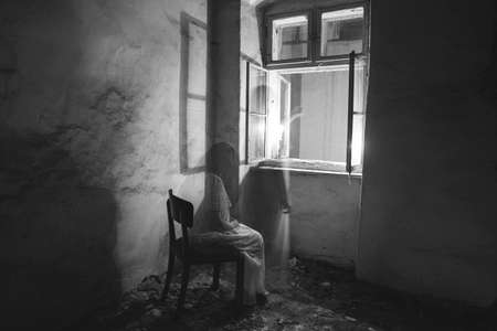 Ghost in abandoned, haunted house. Horror scene of scary spirit of a woman, halloween concept.