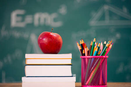 Back to School Concept. Apple, accessories and books against chalkboard.の写真素材