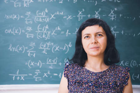 Teacher or student in school classroom, math lesson in the background