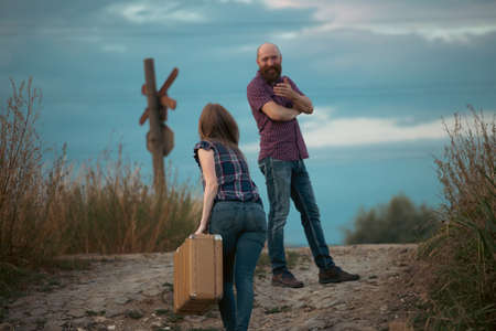 Young couple holding vintage suitcase at the railway station platformの写真素材