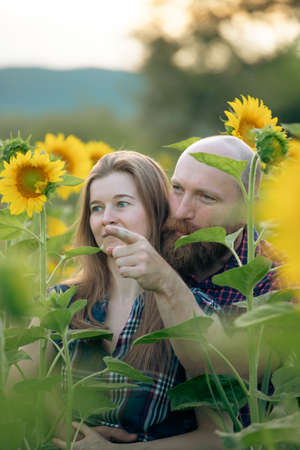 Romantic couple on a love moment in a sunflower fieldの写真素材