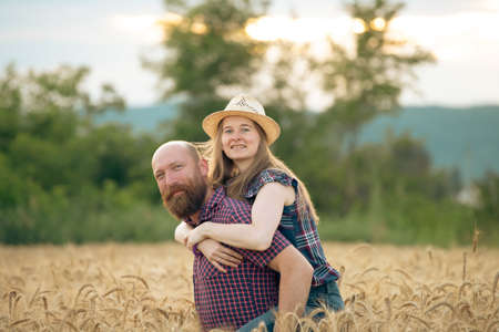 Couple having fun and enjoying relaxation in a wheat field. The concept of youth, love and lifestyle.の写真素材