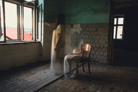 Ghost in abandoned, haunted house. Horror scene of scary spirit of a woman, halloween concept.の写真素材