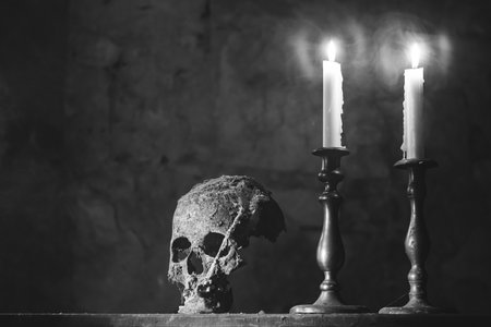 Real human skull with candles in the darkness. Spooky, horror wallpaper for Halloween.の写真素材
