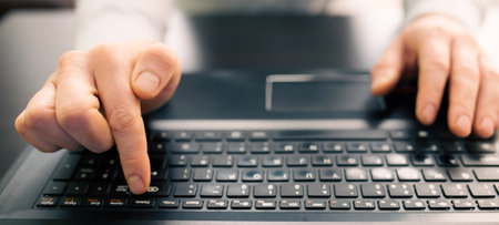 Close up of business man hand working on laptop computer on wooden desk as conceptの写真素材