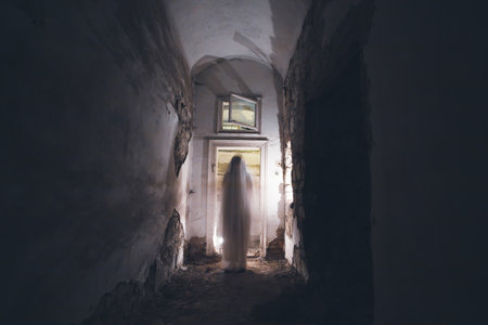 Ghost in abandoned, haunted house. Horror scene of scary spirit of a woman, halloween concept.の写真素材