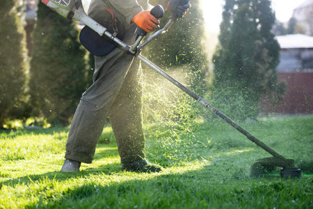 Mowing the grass with a lawn mower. Garden work concept background.の写真素材