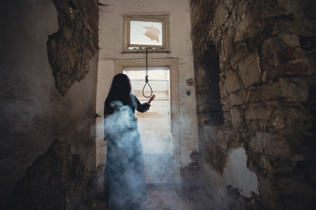 Ghost in abandoned, haunted house. Horror scene of scary spirit of a woman and rope with a noose, halloween concept.の写真素材