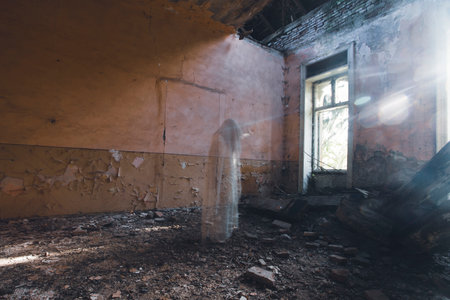 Ghost in abandoned, haunted house. Horror scene of scary spirit of a woman, halloween concept.の写真素材