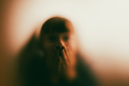 Scared, screaming girl behind the matte glass. Halloween festival concept.の写真素材