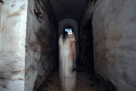 Ghost in abandoned, haunted house. Horror scene of spooky silhouette holding old axe, halloween concept.の写真素材