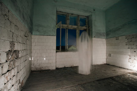 Ghost in abandoned, haunted house. Horror scene of scary spirit of a woman, halloween concept.の写真素材