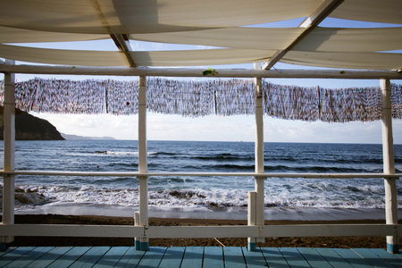 Cozy terrace on the beach, idyllic view of the seashore. Tropical summer vacation concept.の写真素材