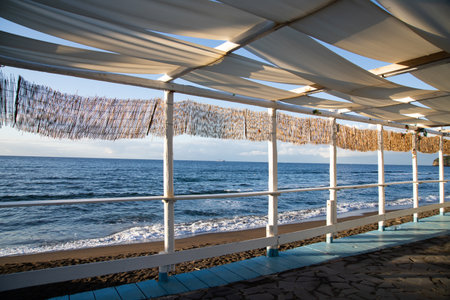 Cozy terrace on the beach, idyllic view of the seashore. Tropical summer vacation concept.の写真素材