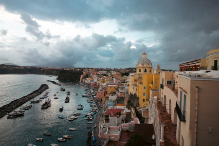 View of the Port of Corricella with lots of colorful houses after sunset in Procida Island, Italy.の写真素材