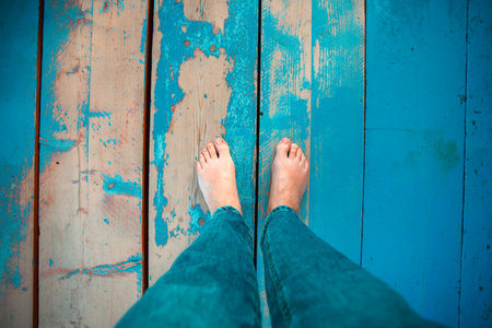 Woman leg's on wooden beach jetty. Barefeet on wooden planks. Unrecognizable person walking barefeetの写真素材
