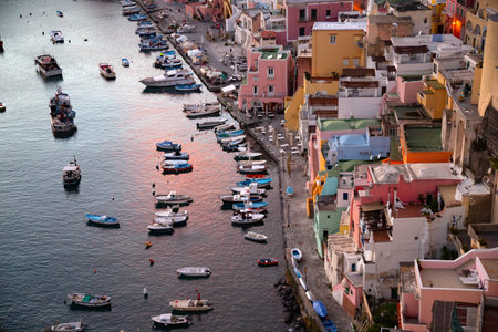 View of the Port of Corricella with lots of colorful houses in the sunset, Procida Island, Italy.の写真素材