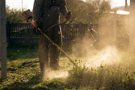 Mowing the grass with a lawn mower. Garden work concept background.の写真素材