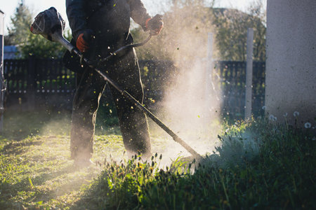 Mowing the grass with a lawn mower. Garden work concept background.の写真素材