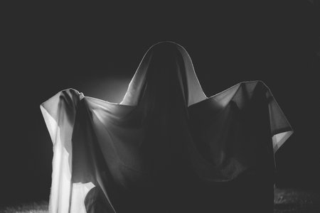 Horror background of a ghostly figure on a dark Halloween night.の写真素材