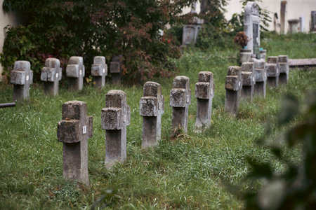 Misty view of dark stone crosses and tombstones in a deserted graveyard. Halloween conceptの写真素材