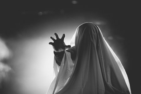 Horror background of a ghostly figure on a dark Halloween night.の写真素材
