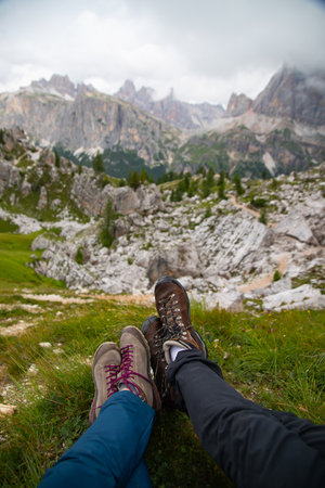 Legs of traveler sitting on a high mountain top in Dolomite mountains, Italy. Concept of freedom, adventure, summer vacation activityの写真素材