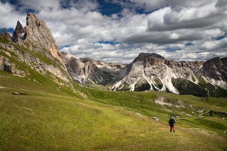 Young man hiking in the Dolomites (Italy) on Seceda mountain, on a summer day.の写真素材