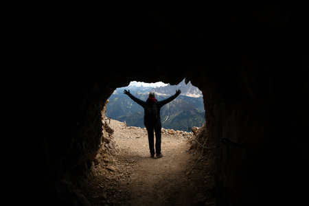 Young woman hiking in the Dolomites (Italy) on Marmolada mountain, on a stormy summer day.