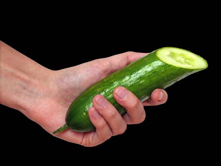 Hand holding a cucumber on black backgroundの写真素材