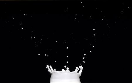 Crown-shaped splash of milk on black backgroundの写真素材