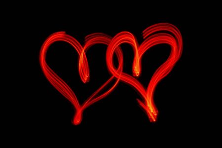 couple of red hearts on black backgroundの写真素材