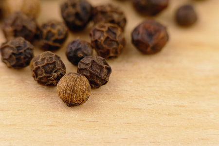 close-up of a black pepper (Piper nigrum) on the wooden surfaceの写真素材