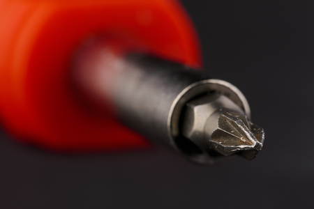 close-up of a screwdriver with red handle on black backgroundの写真素材