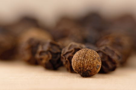 close-up of a black pepper (Piper nigrum) on the wooden surfaceの写真素材