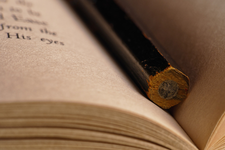 close-up of a black pencil inside of an open bookの写真素材