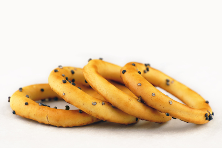 Dry bread-rings with poppy seeds. bunch of bagels lying on white surfaceの写真素材