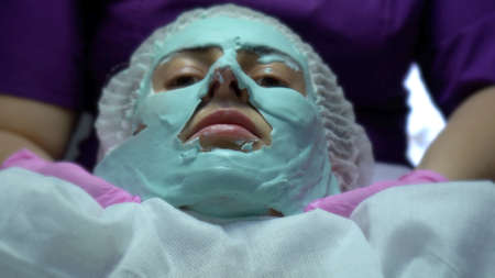 Woman at beautician. Face injections and calming skin mask treatments.