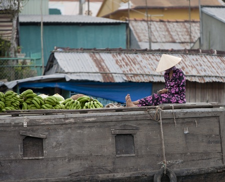 CAN THO, VIETNAM - DECEMBER 6, 2012: Unidentified Vietnamese woman counting money on the roof of her boat at the Floating Market in Can Tho, december 6, 2012 in Vietnam. のeditorial素材