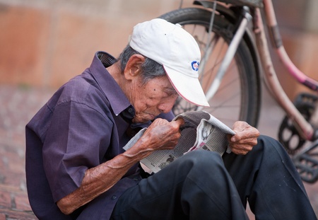 HO CHI MINH CITY, VIETNAM - DECEMBER 10, 2011: Unidentified Vietnamese old man reading the newspaper on the streets of Ho Chi Minh City, december 10, 2011 in Vietnam. 
のeditorial素材
