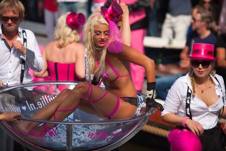 AMSTERDAM, THE NETHERLANDS - AUGUST 4, 2012: Woman in lingerie and other participants in front of spectators at the famous Canal Parade of the Amsterdam Gay Pride 2012 on August 4, 2012 in Amsterdamのeditorial素材