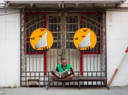 Semarang, Indonesia - September 13th, 2015: Traditional street scene with man reading a newspaper in Semarang, Indonesiaのeditorial素材
