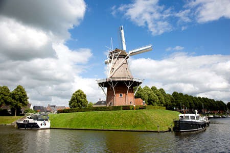 Dokkum, Friesland, The Netherlands - Jun 30, 2019; Boats on canal and windmill on fortifications of historic town Dokkum, Friesland, The Netherlandsのeditorial素材