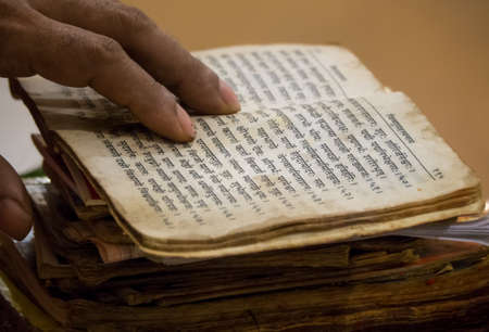 A Pujari read old texts from his heap of books and chanted prayers.の写真素材