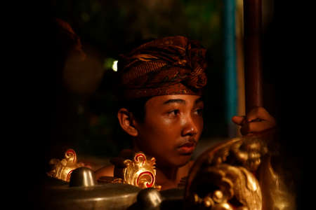 Ubud, Bali-Indonesia-Nov. 13,2014:Young Asian looking boy holding pole wile helping at traditional Balinese danceのeditorial素材